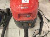 un aspirateur rouge posé par terre