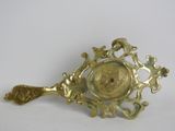 a gold spoon with a face on it and a spoon in the middle