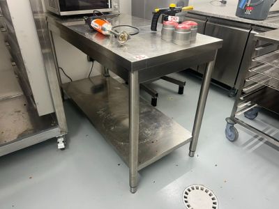 a stainless steel work table with a microwave on it