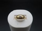 a gold ring with a diamond on top of a white object