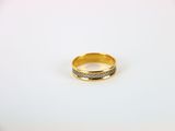 gros plan d'une bague en or sur une surface blanche