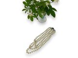 a bouquet of flowers and a bead necklace on a table