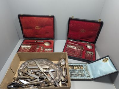 une boîte à couverts posée sur une table et contenant d'autres couverts