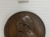 a close up of a bronze medal with a woman on it