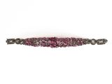 a close up of a pink and black bracelet on a white background