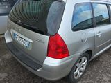 une petite voiture argentée garée devant un immeuble
