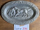 une plaque métallique sur laquelle figurent un chien et un homme