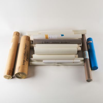 de nombreux rouleaux de papier et des stylos sur la table