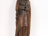 une vieille statue en bois représentant une femme coiffée d'un chapeau