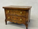 an image of a small wooden chest of drawers on a white background