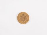 a gold coin on a white surface with a white background