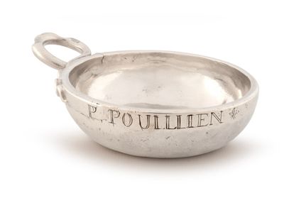 un petit bol en argent avec une poignée sur une surface blanche