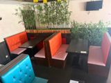 tables and benches in a restaurant with a planter on the wall