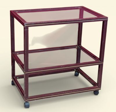 une table en verre avec un piètement en métal et des roulettes