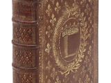 un vieux livre marron avec un motif doré sur la couverture
