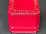 a small red box with a gold design on it