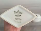 a person holding a small white plate with a picture on it