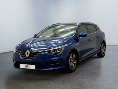 Une voiture bleue est garée dans une pièce aux murs blancs.