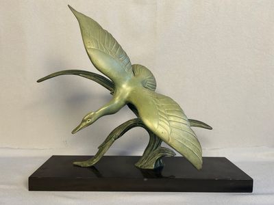 a bronze sculpture of a bird on a black base