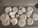 a lot of white plates and cups on the table