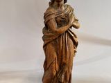 an antique wooden statue of a woman holding a baby