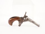un vieux revolver avec un manche en bois sur fond blanc