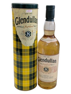 a bottle of glendulan whisky next to a canister