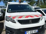 une camionnette blanche garée dans un parking avec d'autres voitures
