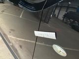 a sticker on the door of a car that is parked in a parking lot