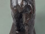 statue of a bear on a wooden base on a green surface