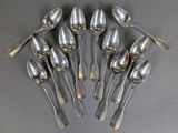 six silver spoons are arranged in a circle on a gray surface