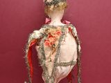 a doll that is on a stick on a red surface