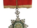une image représentant une médaille entourée d'un ruban rouge