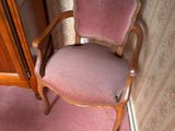a pink chair sitting in a corner of a room