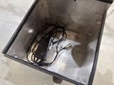 a metal box with a power cord and a charger inside of it