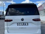 the back of a white vw tourer parked in a parking lot