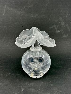 un vase en verre contenant une fleur, posé sur une table
