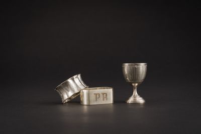 deux coupes en argent et une coupe en argent posée sur une surface noire