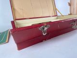 a red suitcase sitting on a table with a key in it