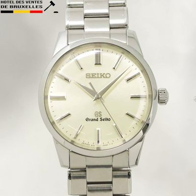 un gros plan d'une montre argentée sur fond blanc