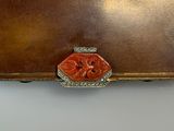 brown leather case with a red flower on the front of it