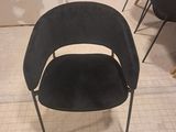 une chaise noire qui se trouve au milieu d'une pièce