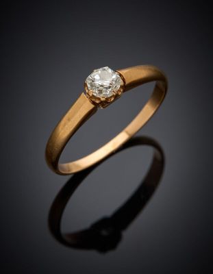 a gold ring with a diamond on a black background