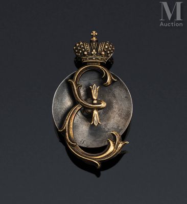 a close up of a gold and silver broochle with a crown on it