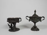 paire de vases en bronze munis d'anses, posés sur des socles, sur fond blanc