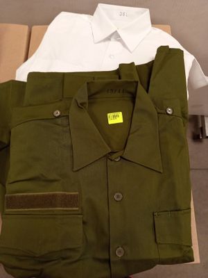 une chemise verte et une chemise blanche posées sur une boîte