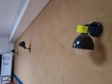 two lights on the wall of a room with a chair in the background