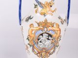 a white vase with a blue handle and a picture on it