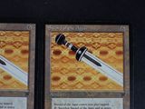 two cards with a sword on them on a table