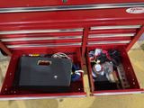 a red tool box with tools in it on the floor